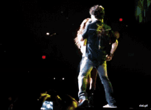 a woman singing into a microphone while a man stands in front of her
