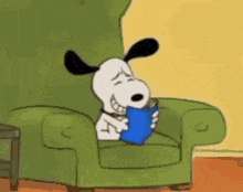 snoopy is reading a book while sitting in a green chair .