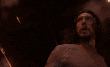 a man is screaming with his arms in the air in a dark room