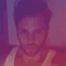 a close up of a man 's face with a purple and blue background