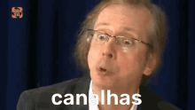 a man wearing glasses says canalhas in a foreign language
