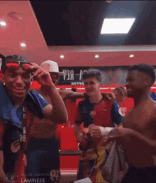 a group of men are posing for a photo in a locker room with a sign that says " a " on it