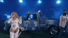 a woman stands in front of a truck with the letter f on the back