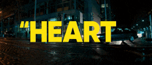 a yellow sign that says " heart " on a wet street