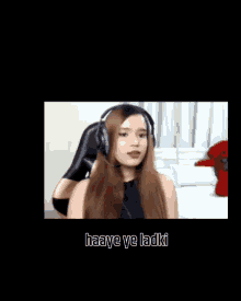 a woman wearing headphones with the words haaye ye ladki written below her