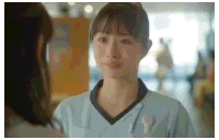 a nurse is talking to a patient in a hospital hallway .