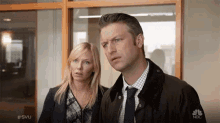 a man and a woman are standing in front of a window with the hashtag #svu on the bottom
