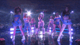 a group of women are dancing on a stage with purple lights behind them