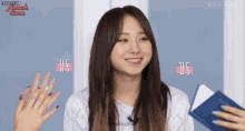 a girl is smiling while holding a book with the words honeycam written on the bottom