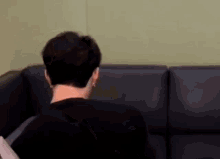 a man is sitting on a couch in a living room .