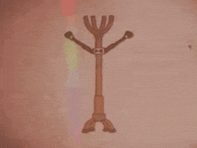 a drawing of a stick man with three arms and a bow tie on a wall .
