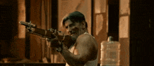 a man in a tank top is holding a gun