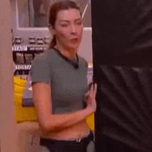 a woman is standing in front of a punching bag .