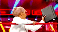 a cartoon of a woman holding a tablet in a wrestling ring