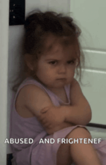 a little girl in a purple dress is sitting with her arms crossed and the words abused and frightened above her