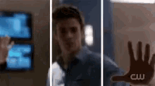 a man is standing in front of a glass door and a hand is reaching out towards him .