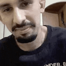 a close up of a man with a beard wearing a black sweater .