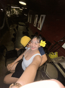 a woman wearing a flower in her hair is sitting next to a man