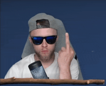 a man wearing sunglasses giving the middle finger