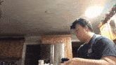 a man standing in a kitchen with a container of kraft singles