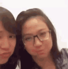 two women wearing glasses are standing next to each other .