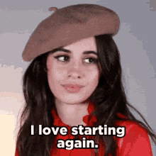 a woman wearing a beret and a red shirt is saying `` i love starting again . ''