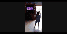 a little girl is dancing in front of a television .