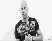 a man wearing a black american eagle t-shirt clapping his hands