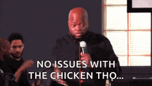 a man holding a microphone says no issues with the chicken tho