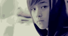 a close up of a young boy wearing a hooded sweatshirt .