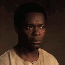a man with a serious look on his face is wearing a white shirt