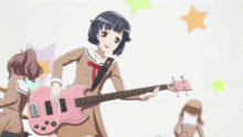 a girl in a school uniform is holding a pink guitar .