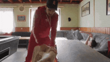 a man wearing a hat with the letter b on it stands next to a couch