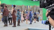 a group of people are dancing on a green screen