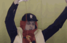a person wearing a hat with the letter x on it is pouring ketchup from a bottle