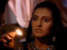 a woman holding a lit match in her hand