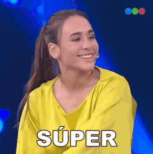 a woman in a yellow shirt is smiling and the word super is on her shirt