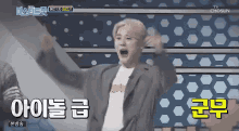 a man is standing on a stage with his arms in the air and screaming .