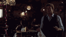 a man stands in a dark room holding a sign that says ' i 'm sorry ' on it