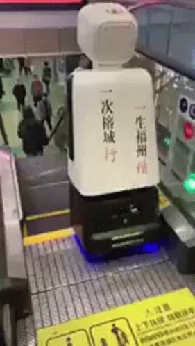 a robot is sitting on the bottom of an escalator with chinese writing on it
