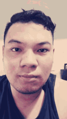 a close up of a man 's face with a black shirt on