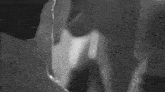 a black and white photo of a man and woman kissing each other .