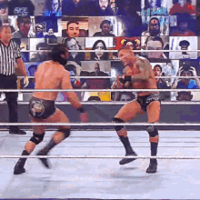 two men are fighting in a wrestling ring with a referee watching