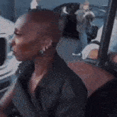 a woman with a bald head is sitting in a car .