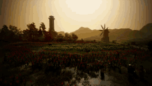 a field of red flowers with a windmill in the distance