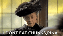 a woman in a feathered hat is saying i dont eat chunks rina .