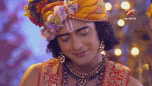 a close up of a man wearing a turban and a necklace with a star in the background