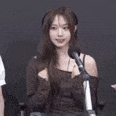 a woman is sitting in front of a microphone wearing headphones .