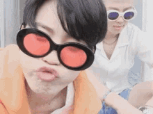 a couple of people wearing sunglasses are making a face .