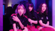 three girls are sitting next to each other with one wearing a shirt that says ' 0001 0004 ' on it